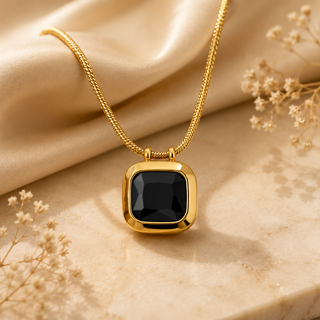 Halskette mit schwarzem Zirkonia – eleganter goldener Edelstahlanhänger auf einfarbigem Hintergrund